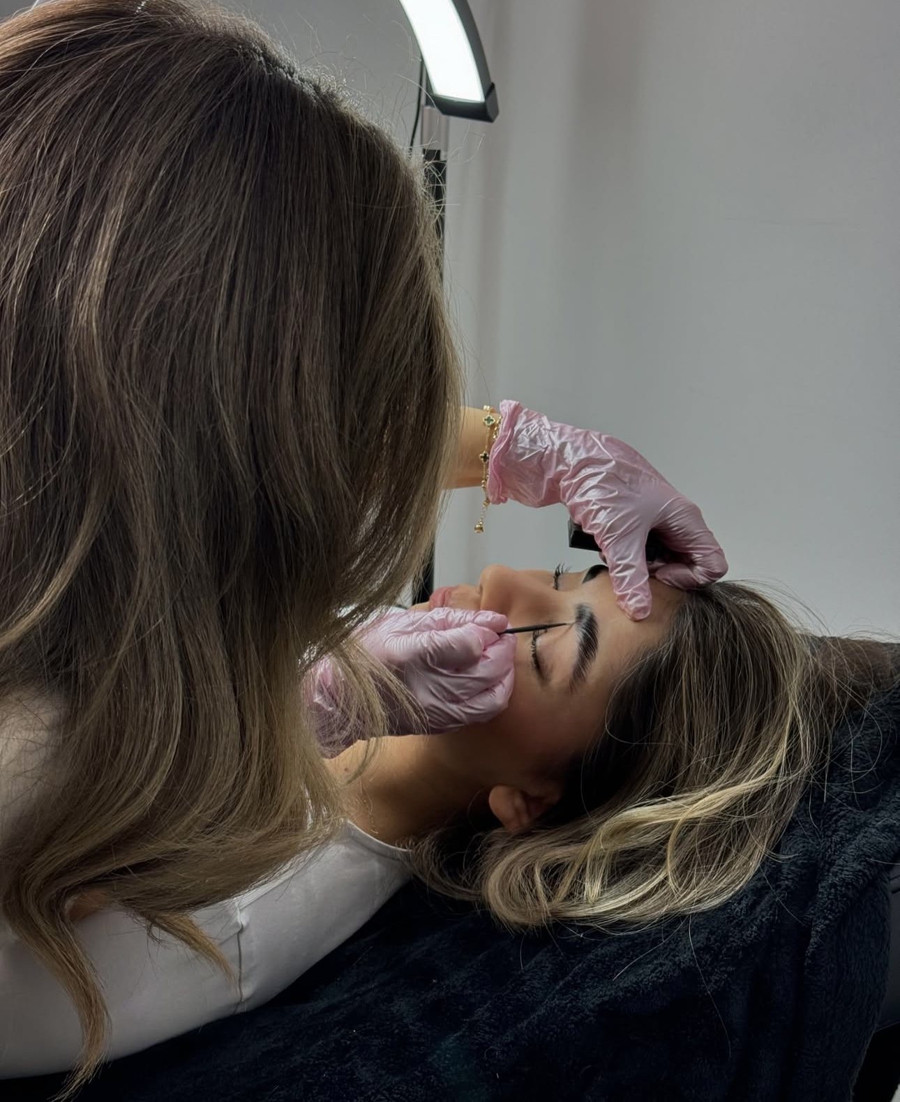 Elyesa aan het werk aan de wenkbrauwen van een klant