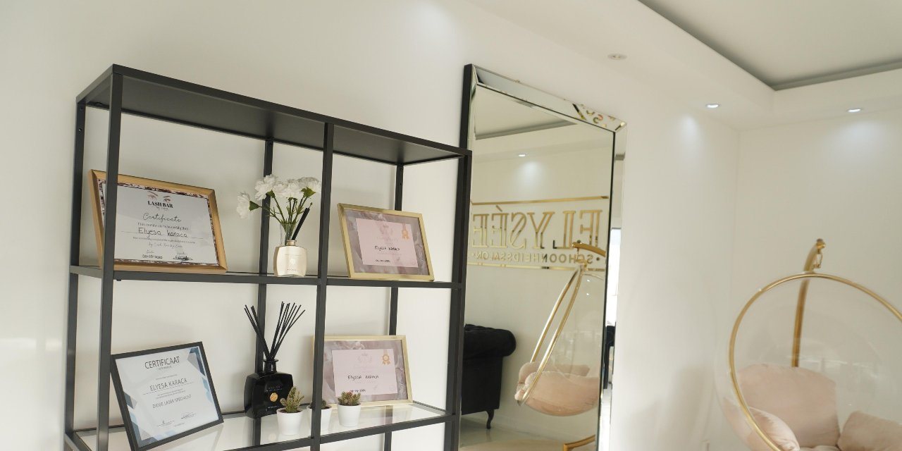 Het wandrek in de salon met ingelijste certificaten op naam van Elyesa
